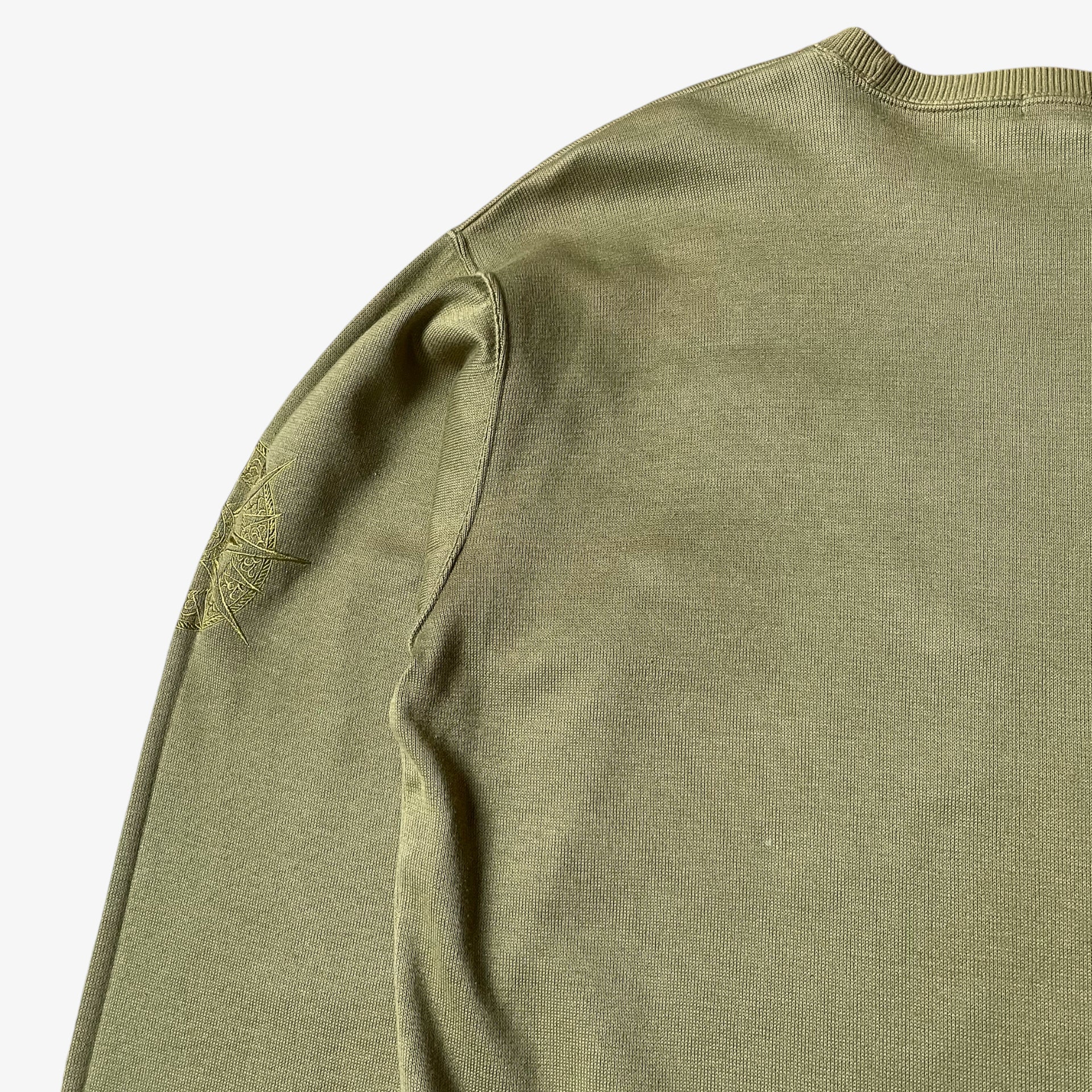 Back wear on a vintage 90s men's Lancel Paris green sweatshirt.