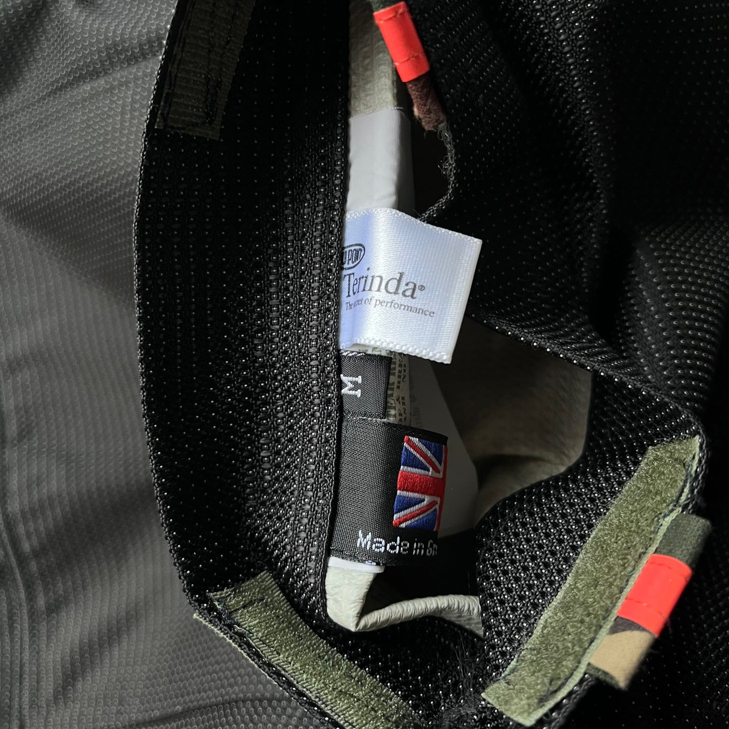 Close up of a size label inside of a black Maharishi utility jacket.