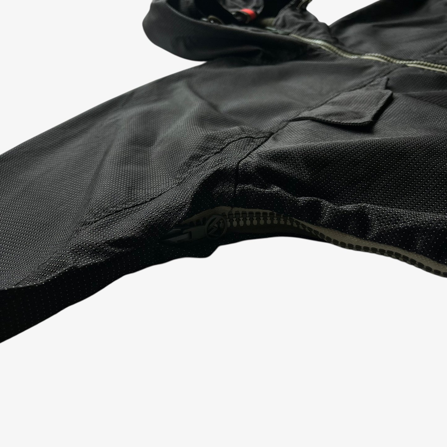 Close up of a black jacket sleeve on a white background.
