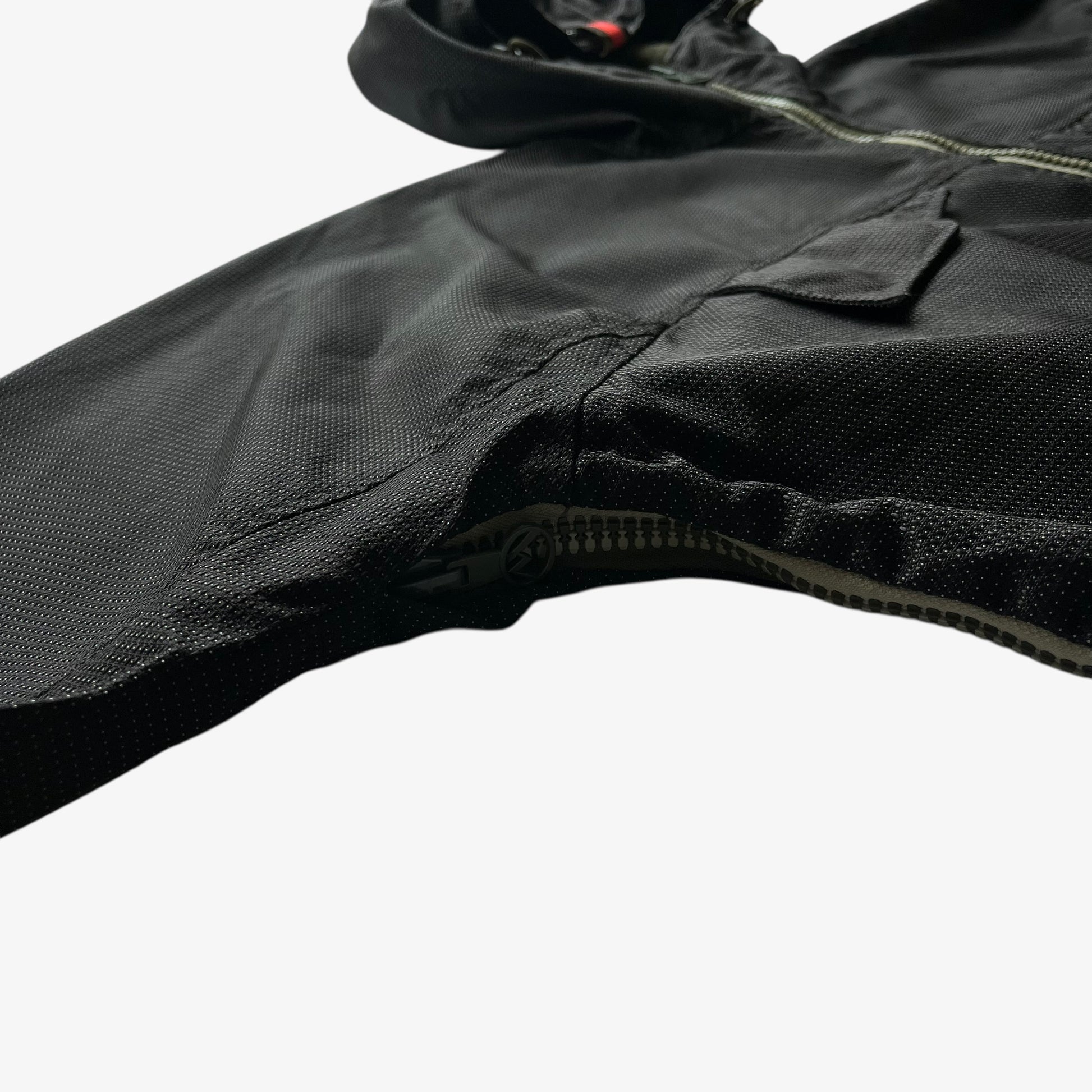 Close up of a black jacket sleeve on a white background.