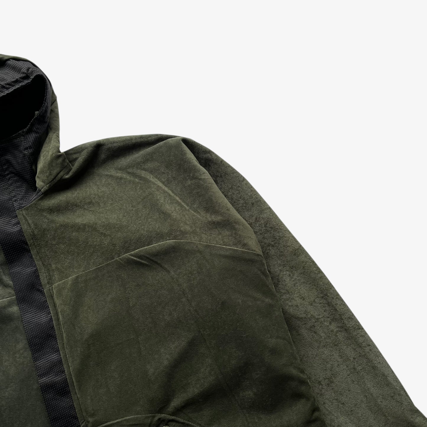 Close up of a green jacket sleeve on a white background.