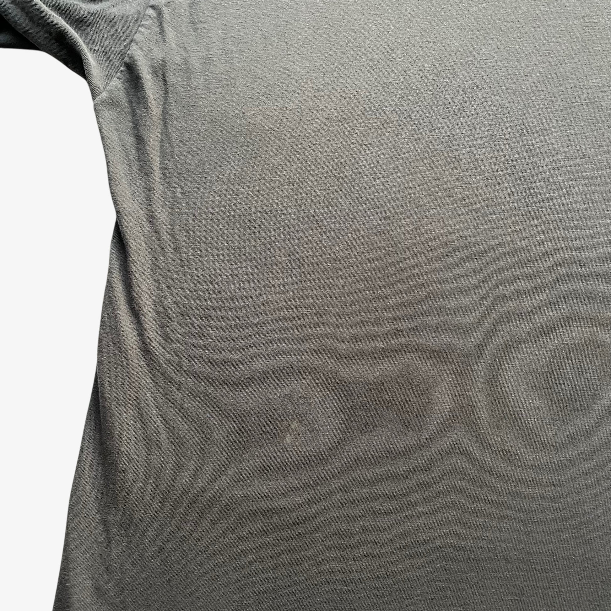 Patina on the back of men's vintage 90s Moschino Jeans no war but love cowboy print t-shirt.