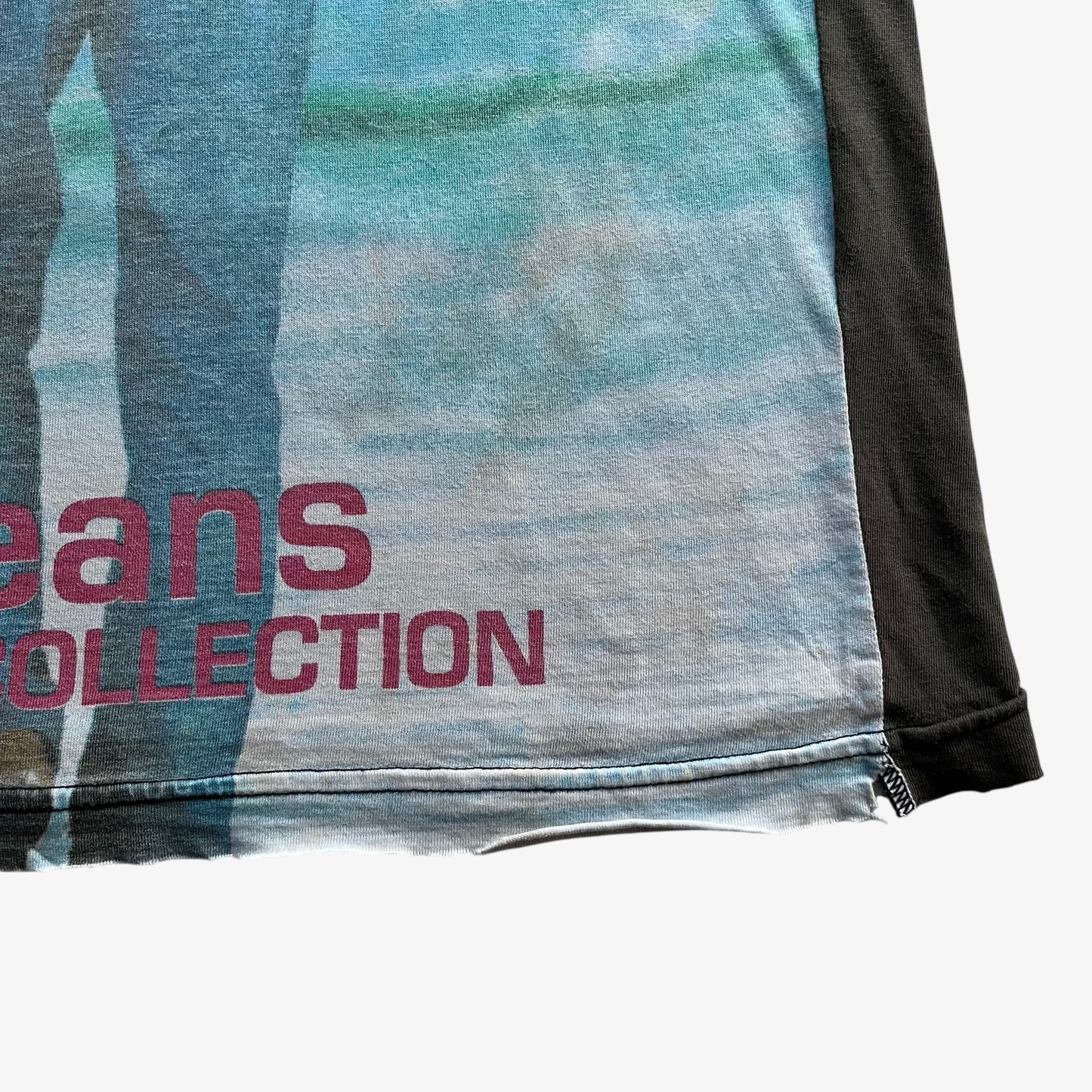 Hem of men's vintage 90s Moschino Jeans no war but love cowboy print t-shirt.