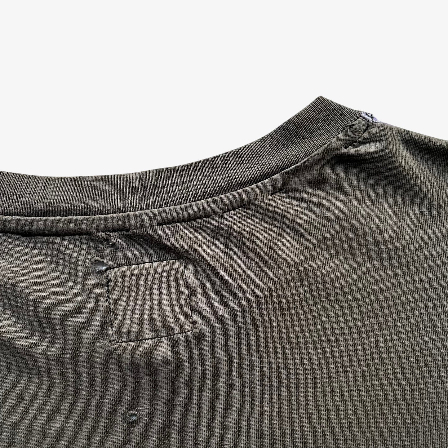 Thrashed collar of men's vintage 90s Moschino Jeans no war but love cowboy print t-shirt.