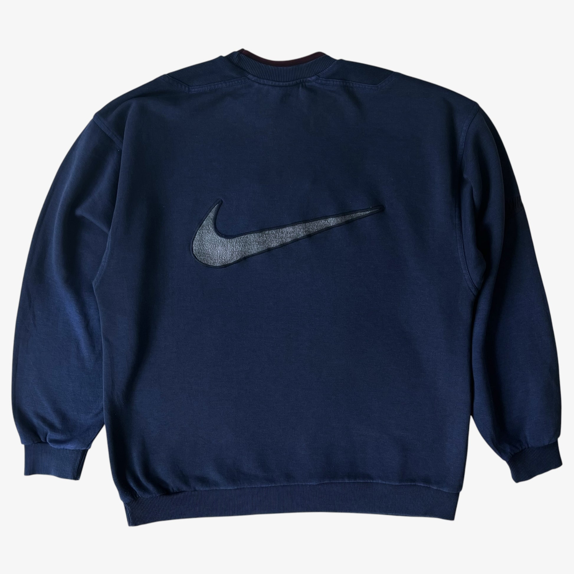 Back of vintage navy nike sweatshirt with a large embroidered tick logo.