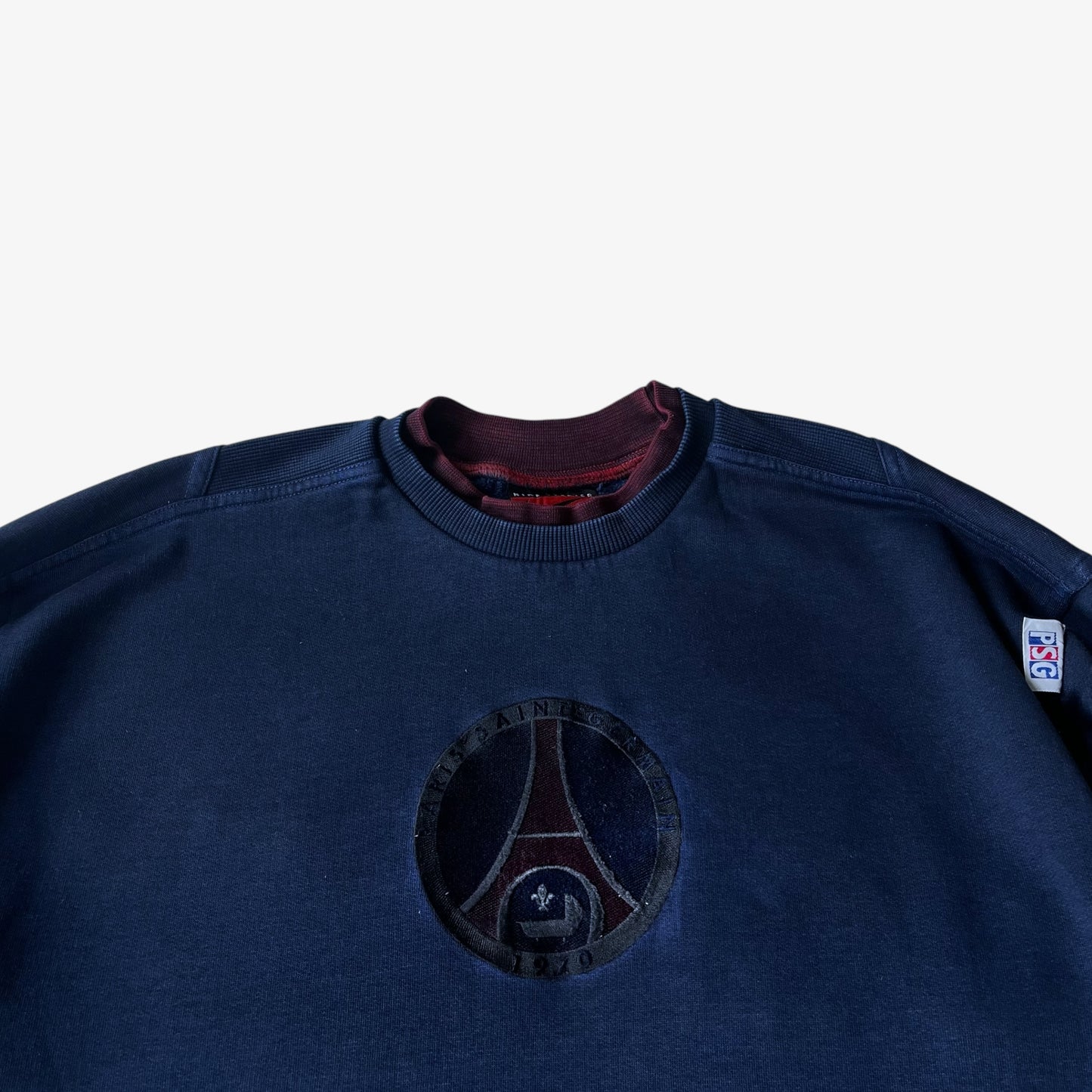 Close up of an embroidered PSG badge on a vintage Nike Premier sweatshirt.