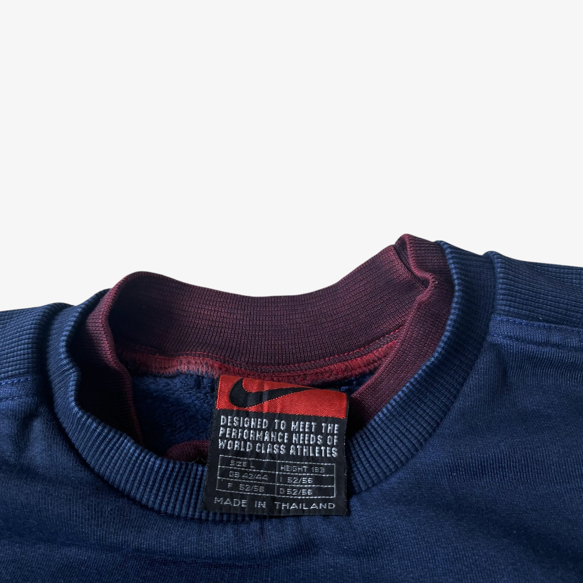 Close up of Nike Premier label stitched inside a vintage navy PSG sweatshirt.