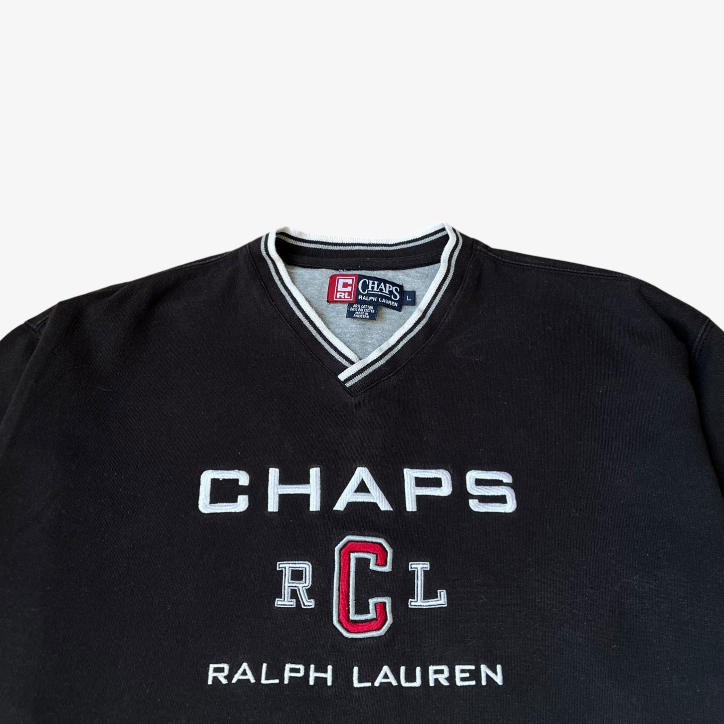 Close up of CHAPS and Ralph Lauren embroidered spell out on a men's vintage black sweatshirt.