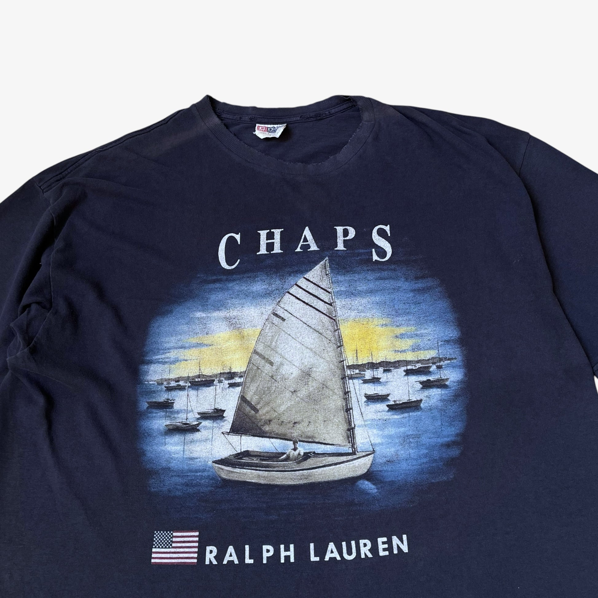 Close up of sailing boat graphic and Ralph Lauren Chaps spell out on a vintage 90s men's thrashed navy t-shirt.