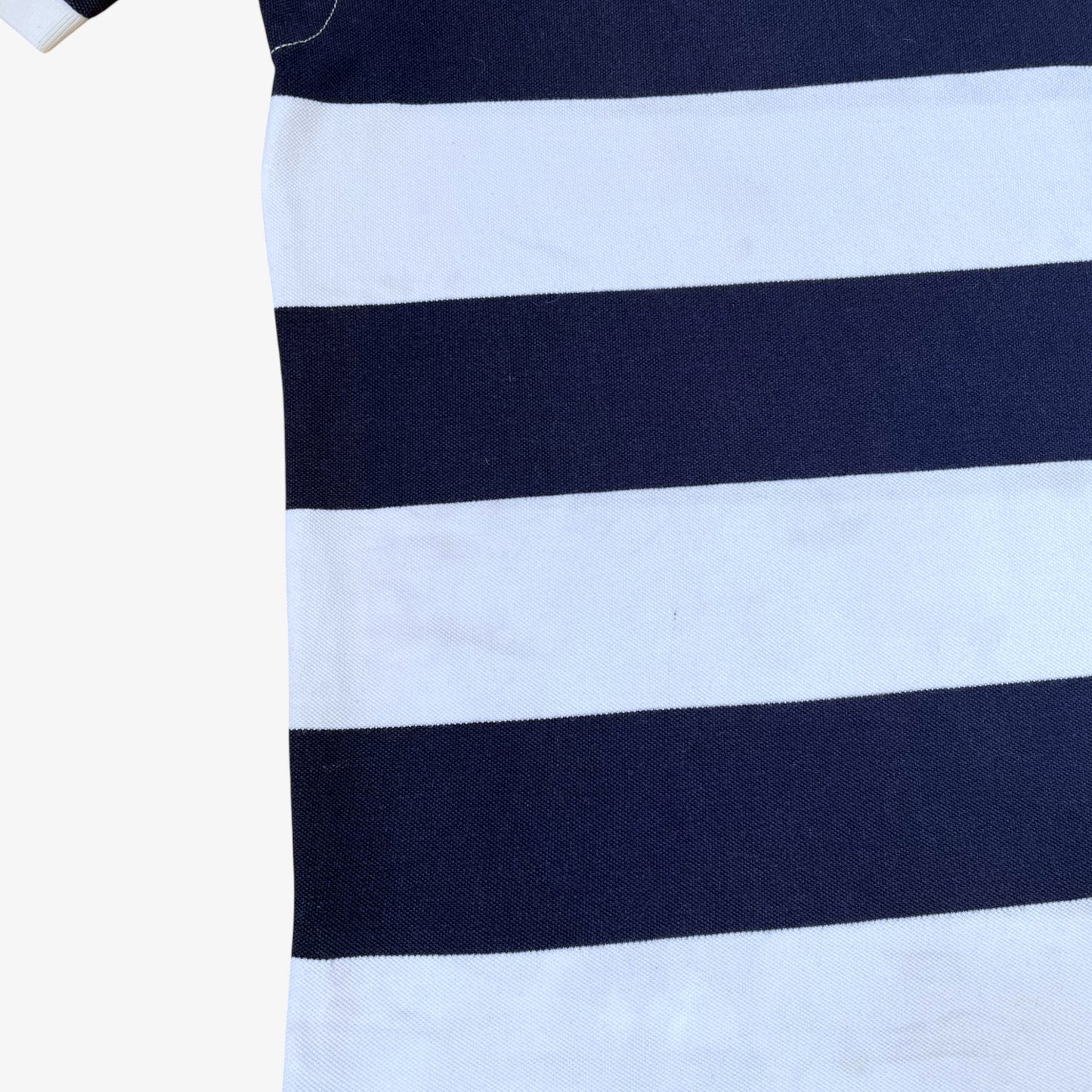 Close up of wear on vintage 90s men's Ralph Lauren navy and white striped polo shirt.
