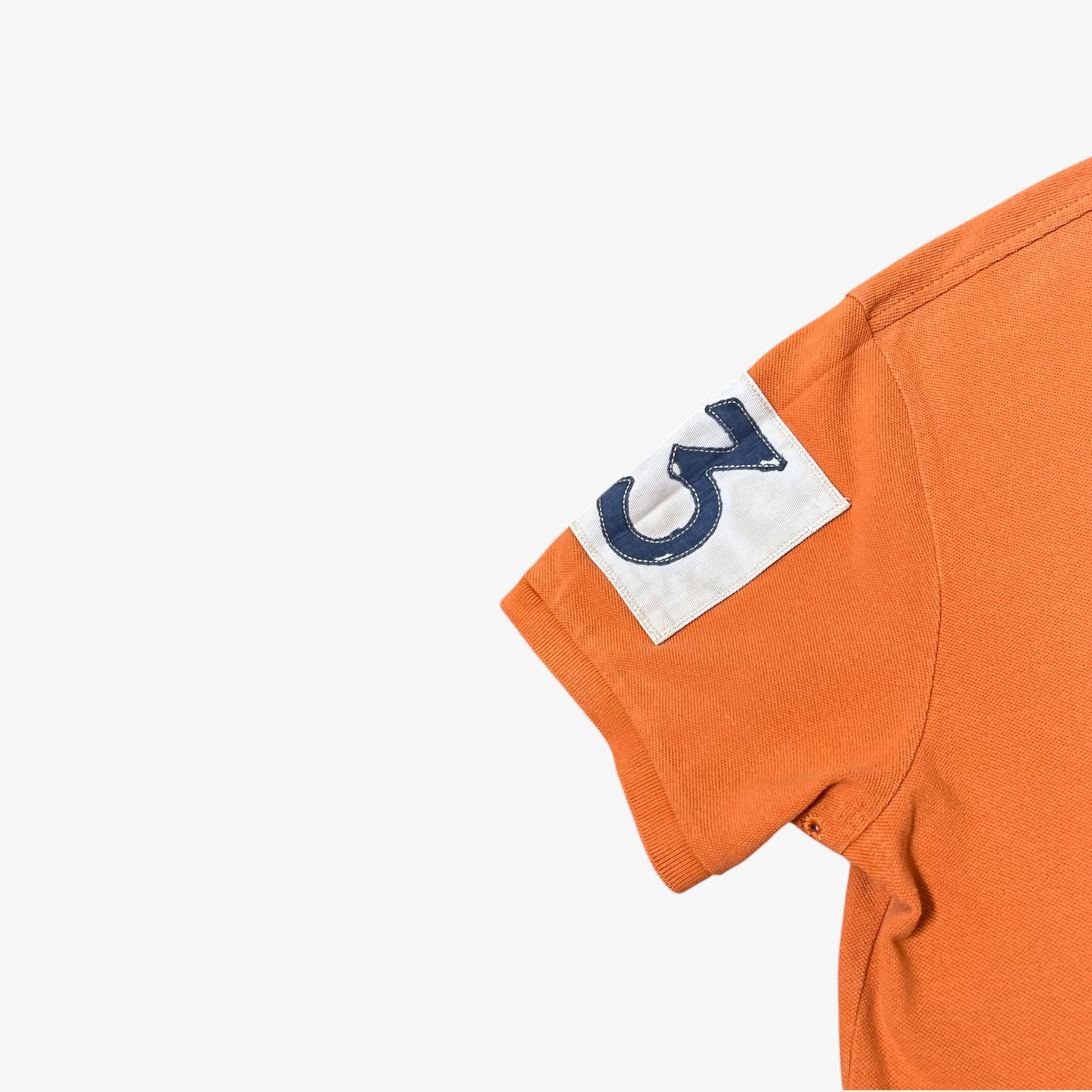 Number 3 badge on the sleeve of vintage Ralph Lauren orange rugby shirt.