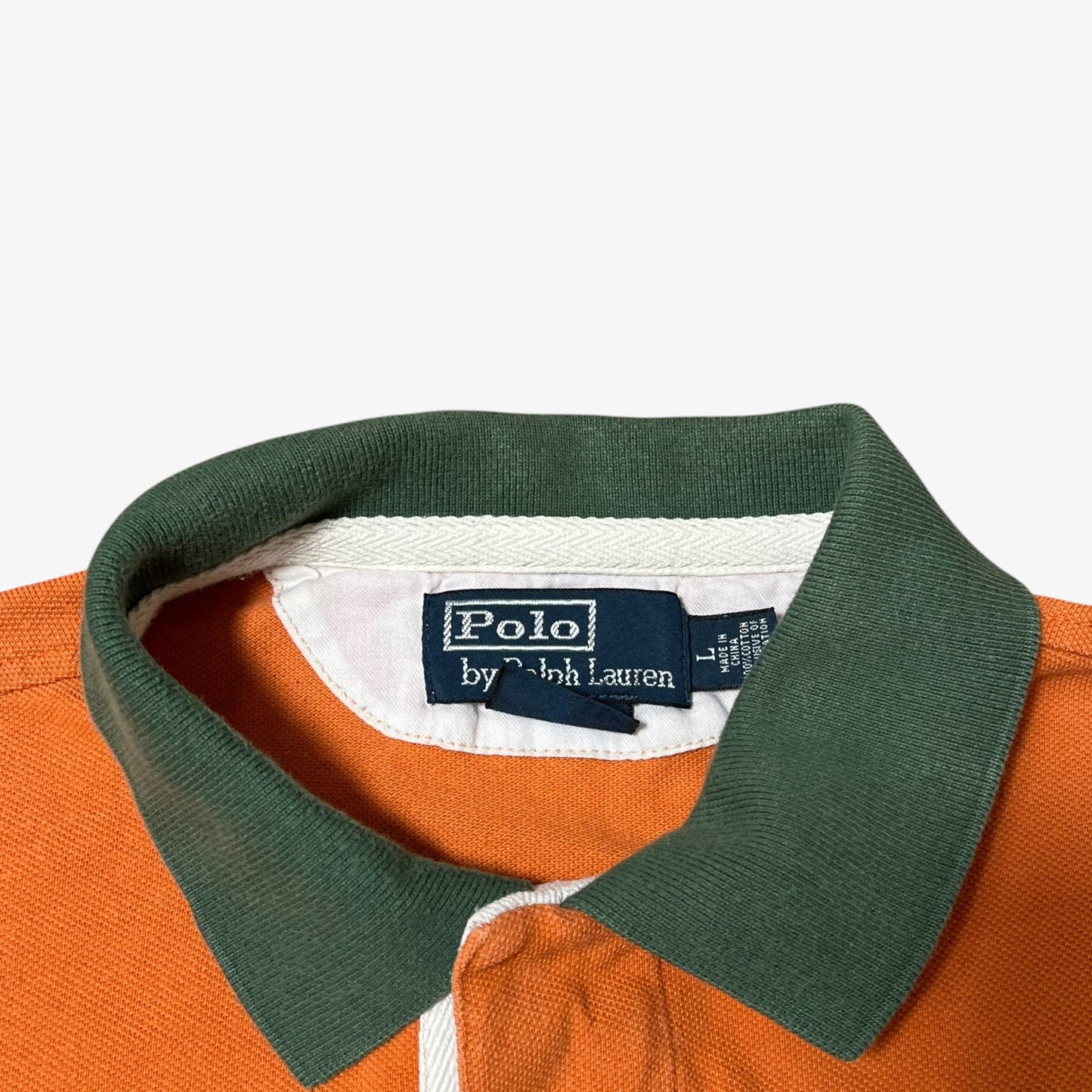 Polo Ralph Lauren label inside of vintage orange rugby shirt with green collar.
