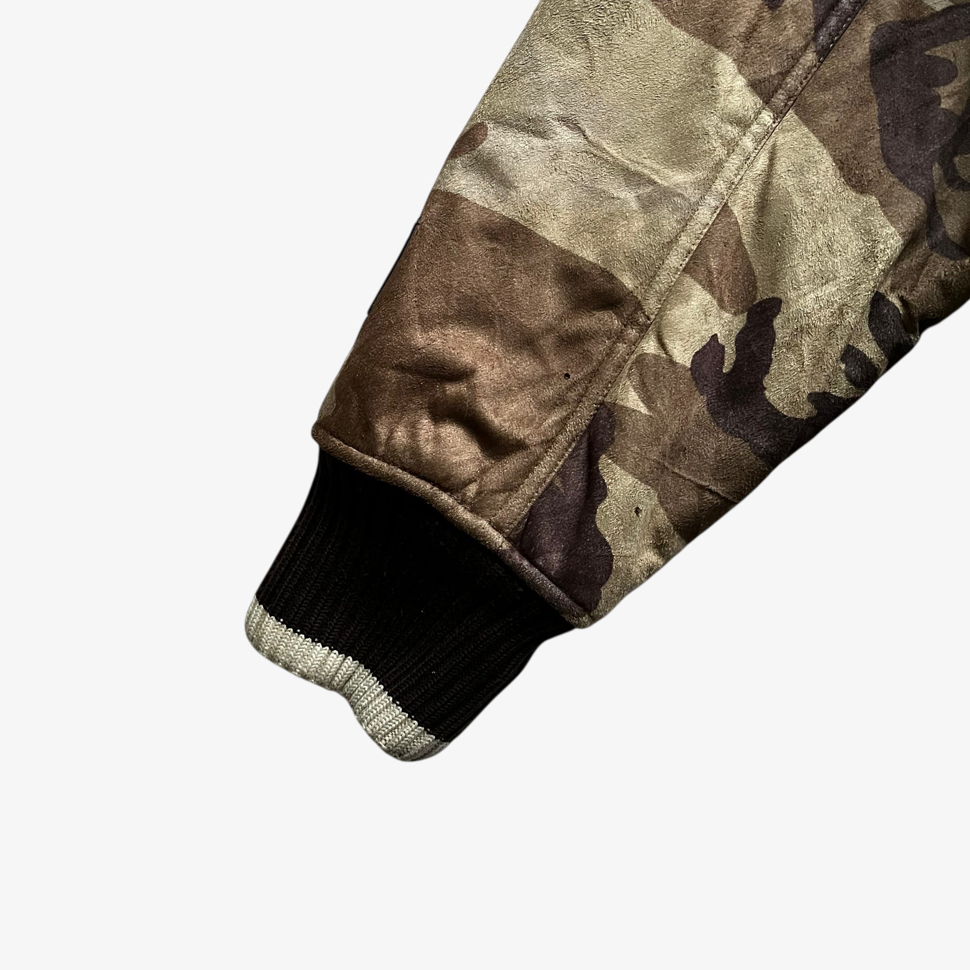 Cuff of vintage 90s men's Sir Benni Miles green camouflage jacket featuring a faux fur hood.