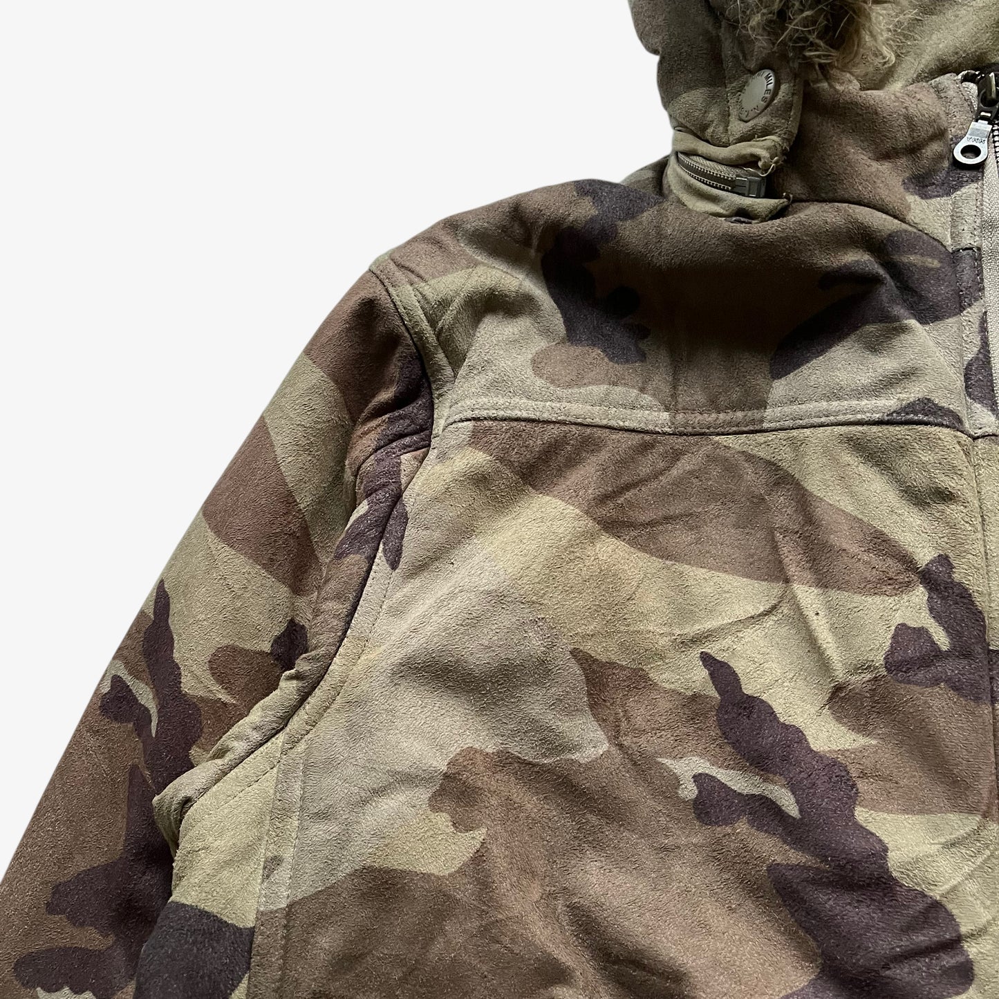 Patina of vintage 90s men's Sir Benni Miles green camouflage jacket featuring a faux fur hood.