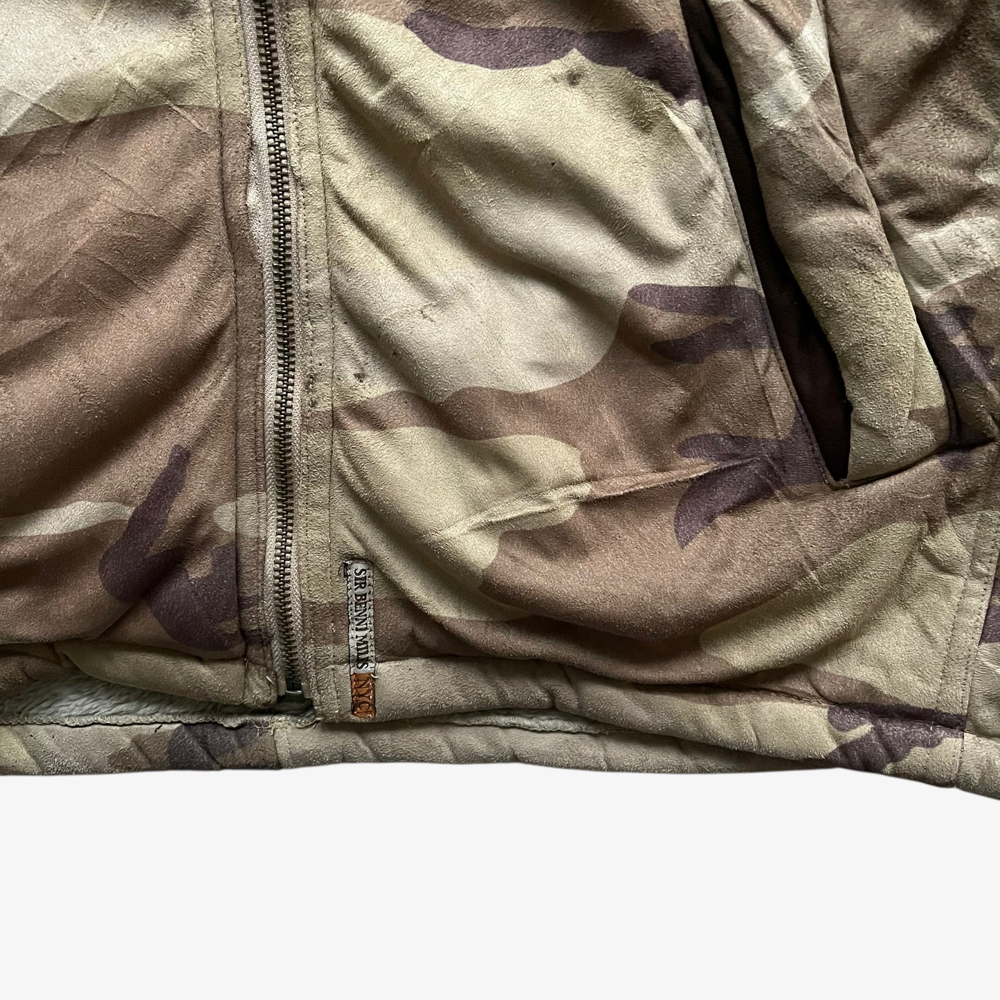 Embroidered tag of vintage 90s men's Sir Benni Miles green camouflage jacket featuring a faux fur hood.