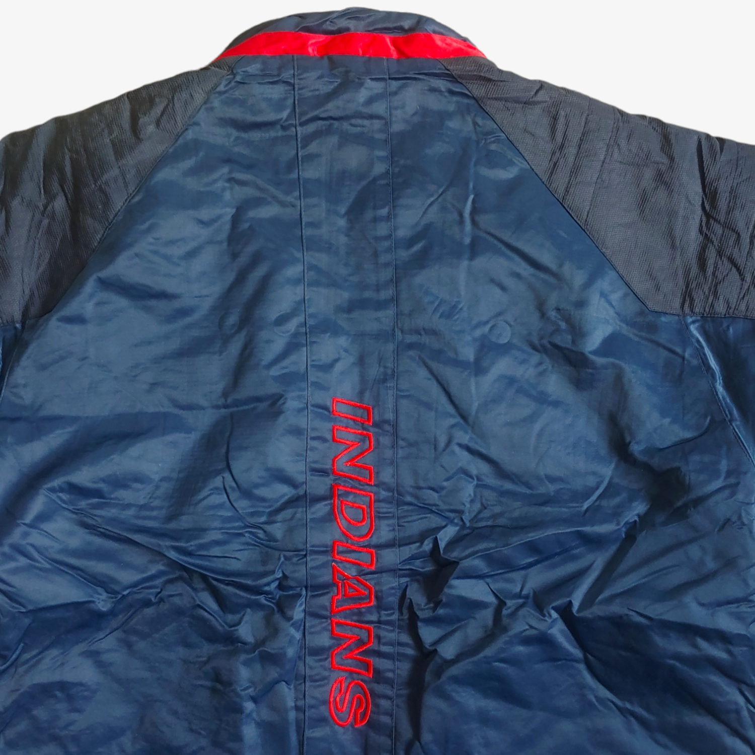 Logo on the back of vintage Starter MLB Cleveland Indians jacket in blue with red and white accents.