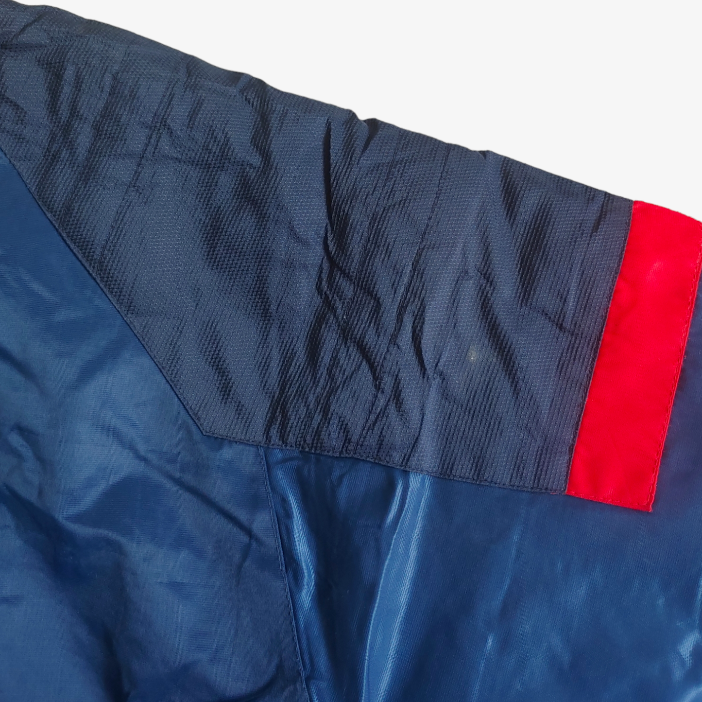 Wear on vintage Starter MLB Cleveland Indians jacket in blue with red and white accents.