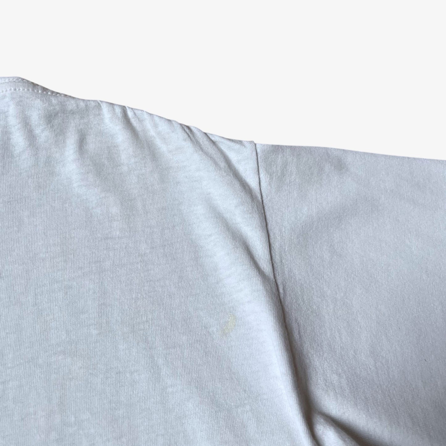 Back wear on vintage 90s men's Stussy studio Jamaica reggae dance hall print white single stitch thrashed t-shirt.