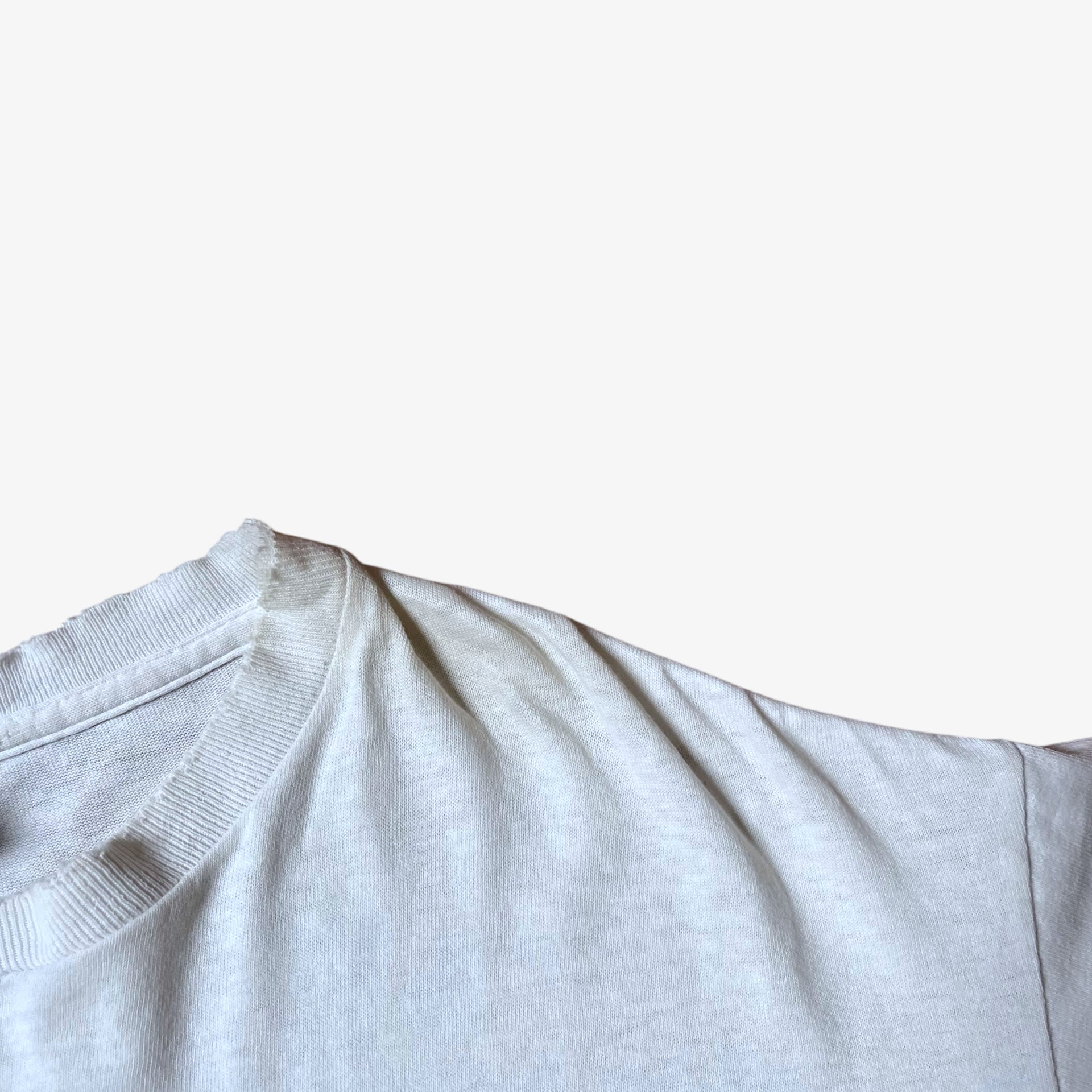 Ribbed collar of vintage 90s men's Stussy studio Jamaica reggae dance hall print white single stitch thrashed t-shirt.