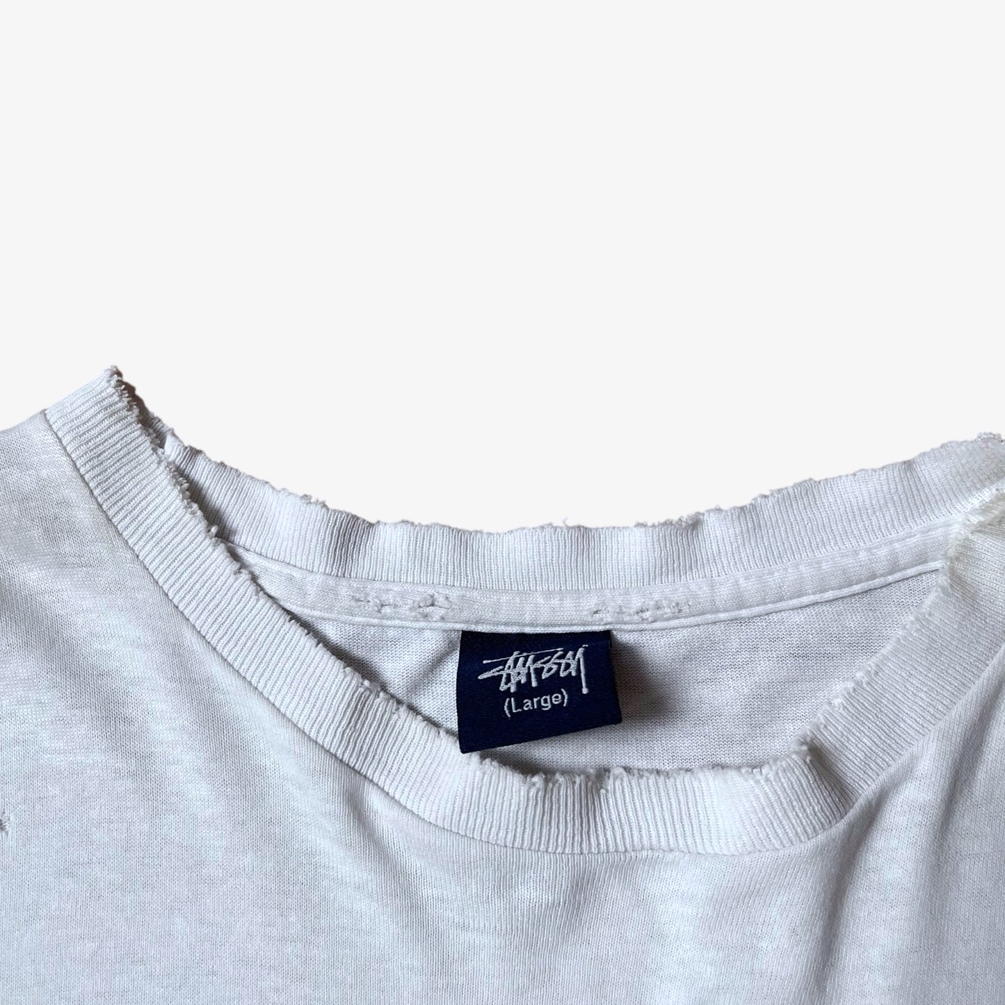 Stussy blue tag label inside of a vintage 90s men's studio Jamaica reggae dance hall print white single stitch thrashed t-shirt.