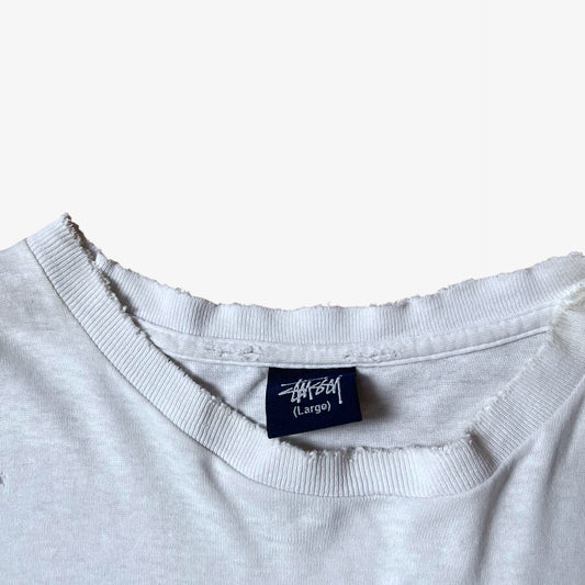 Stussy blue tag label inside of a vintage 90s men's studio Jamaica reggae dance hall print white single stitch thrashed t-shirt.
