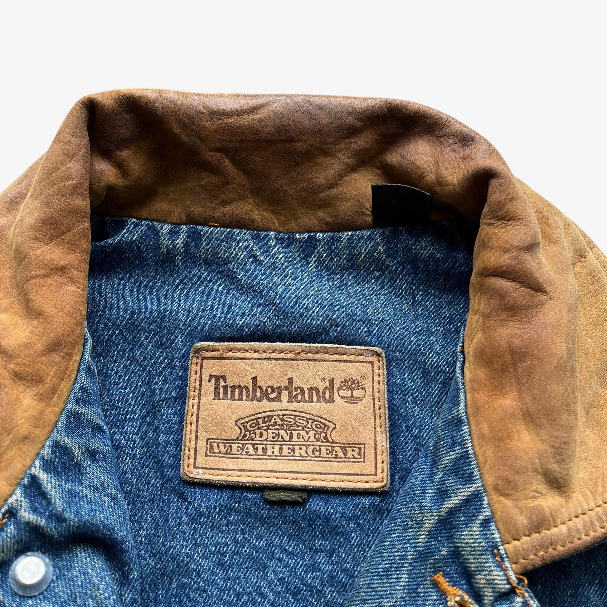 Timberland label of men's vintage 90s blue denim jacket with leather collar and Looney Tunes Marvin Martian print.