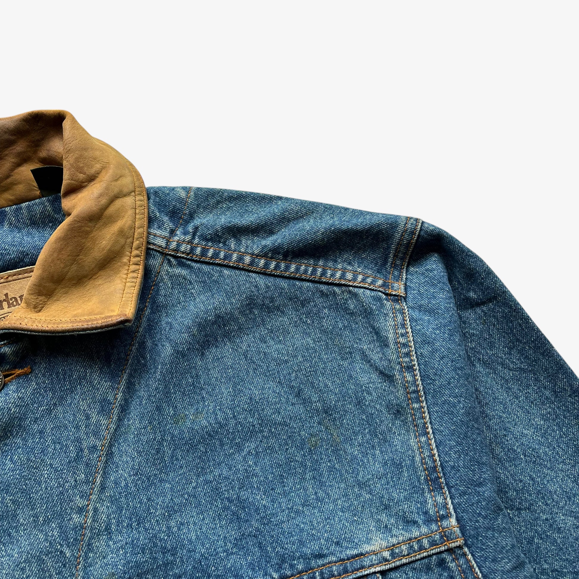 Patina on men's vintage 90s Timberland blue denim jacket with leather collar and Looney Tunes Marvin Martian print.