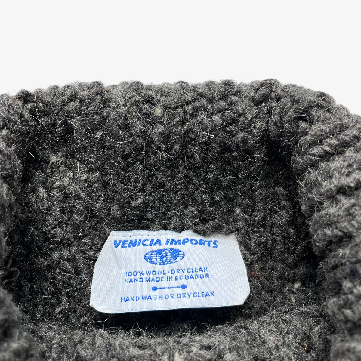 Venicia Imports label stitched inside of a vintage 90s men's grey wool cable knit turtleneck jumper.