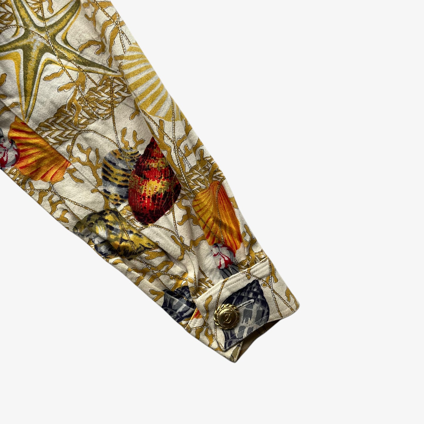 Cuff of vintage 90s women's Christian Llinares CL2 nautical seashell print gold trucker jacket.