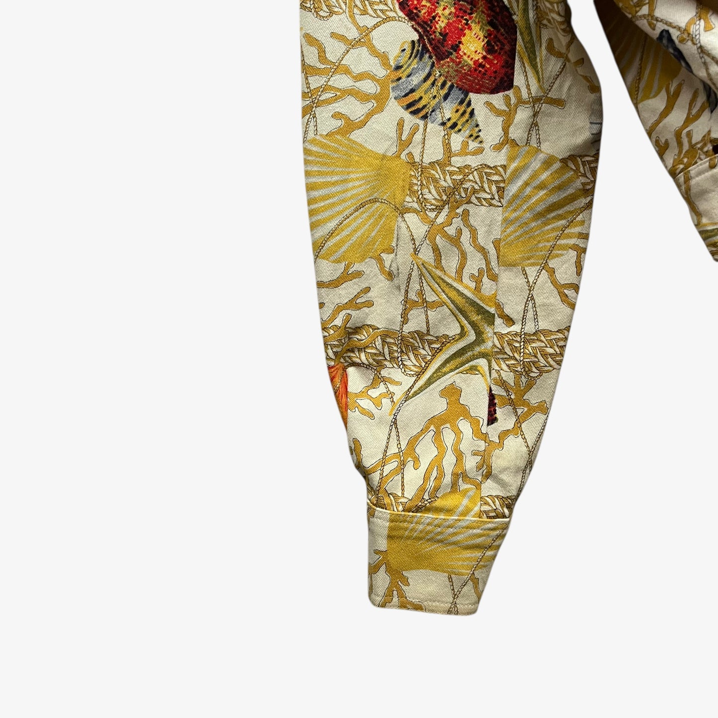 Sleeve of vintage 90s women's Christian Llinares CL2 nautical seashell print gold trucker jacket.