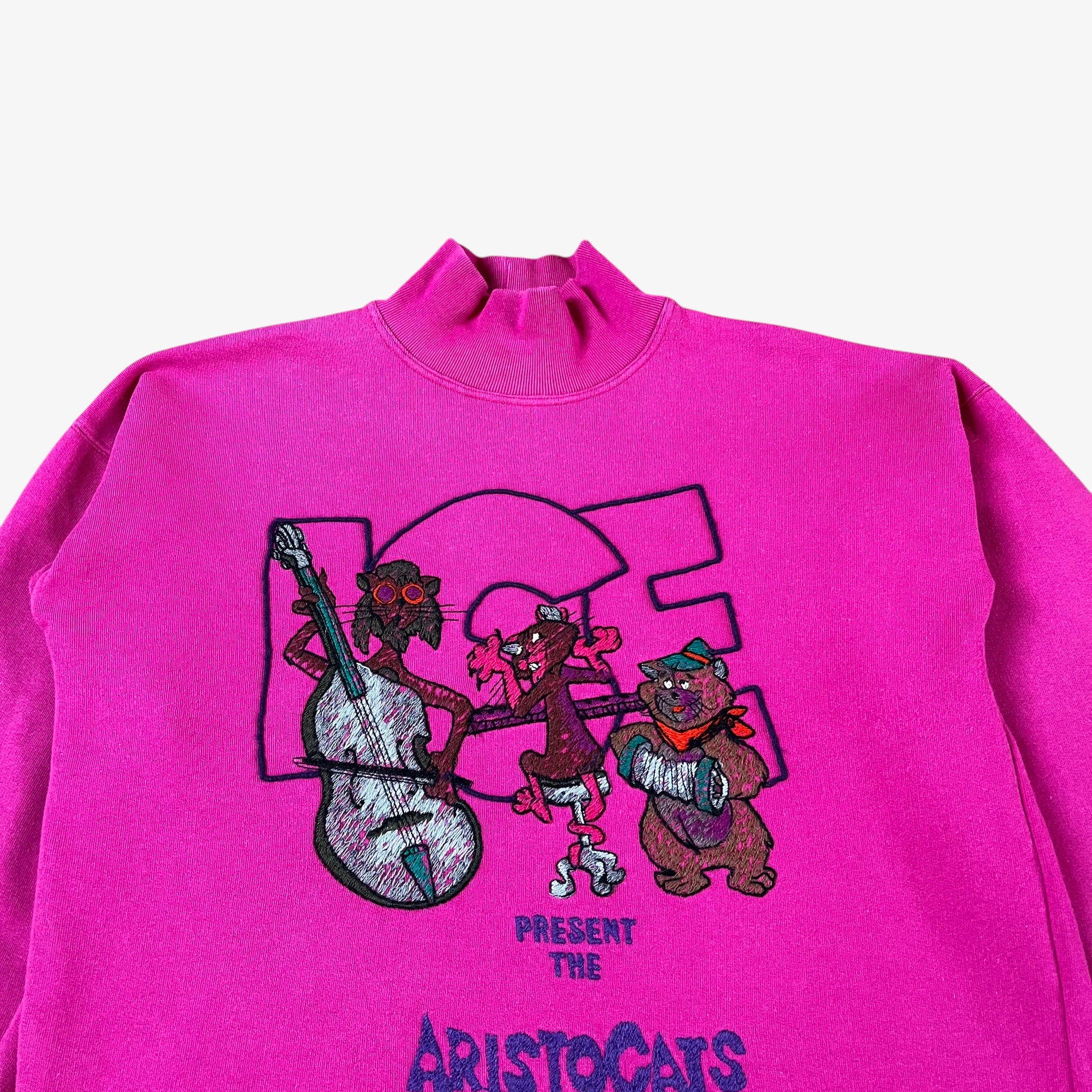 Close up of vintage 90s ICEBERG Disney Aristocats women’s pink turtleneck sweatshirt.