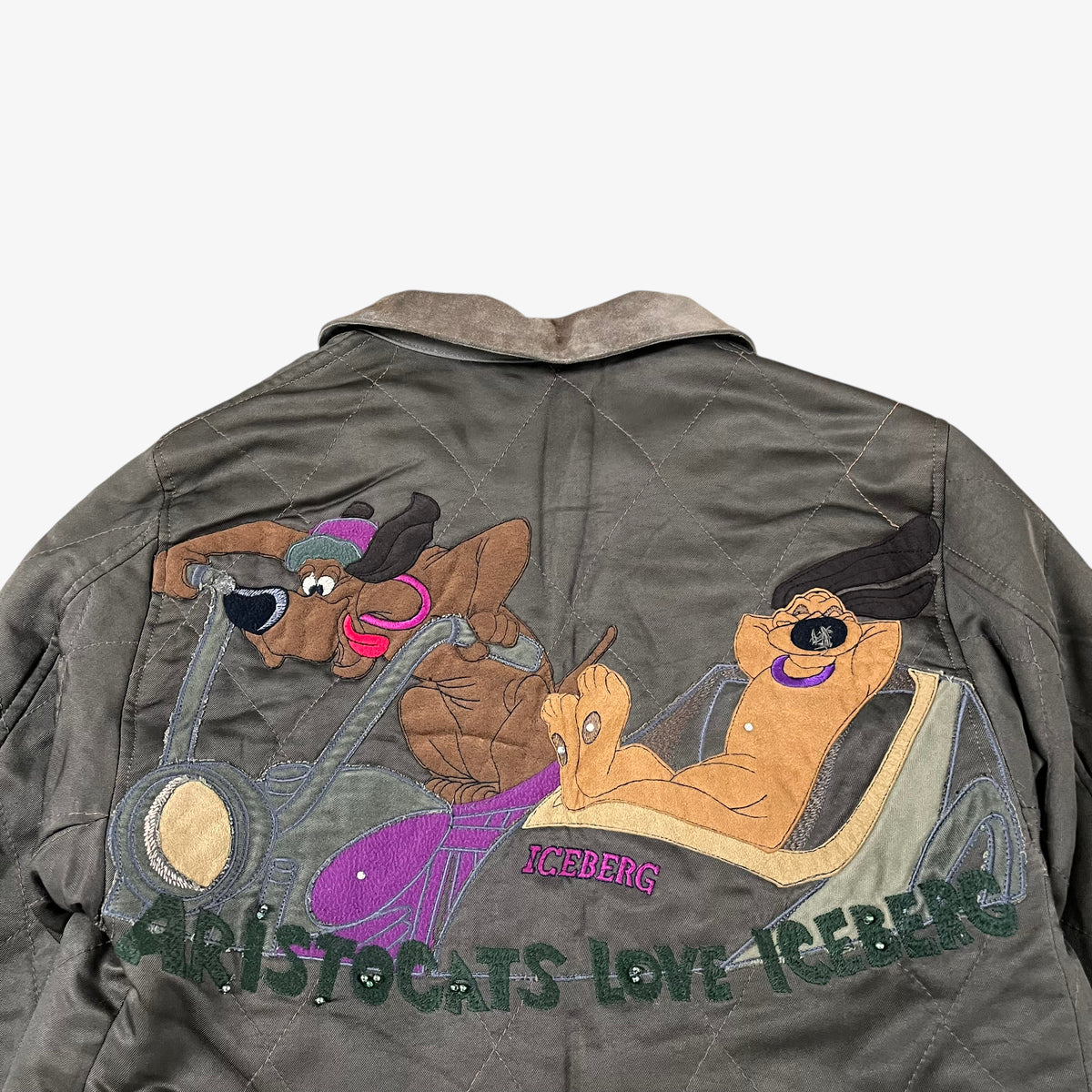 Close up of vintage 90s Iceberg women’s khaki quilted bomber jacket with Disney Aristocats embroidery and brown leather collar.
