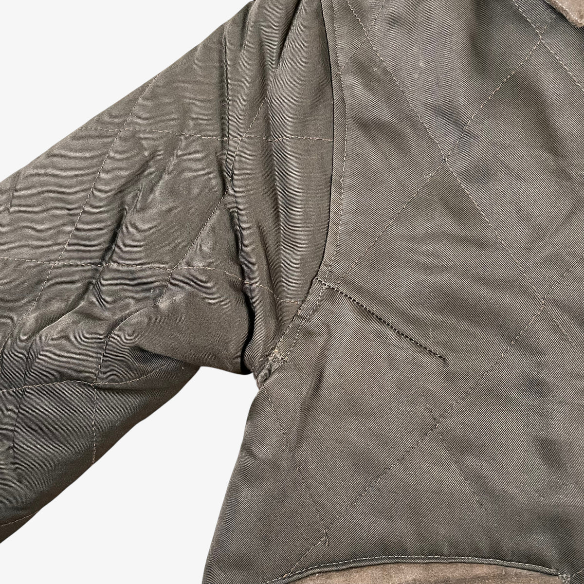 Sleeve of vintage 90s Iceberg women’s khaki quilted bomber jacket with Disney Aristocats embroidery.