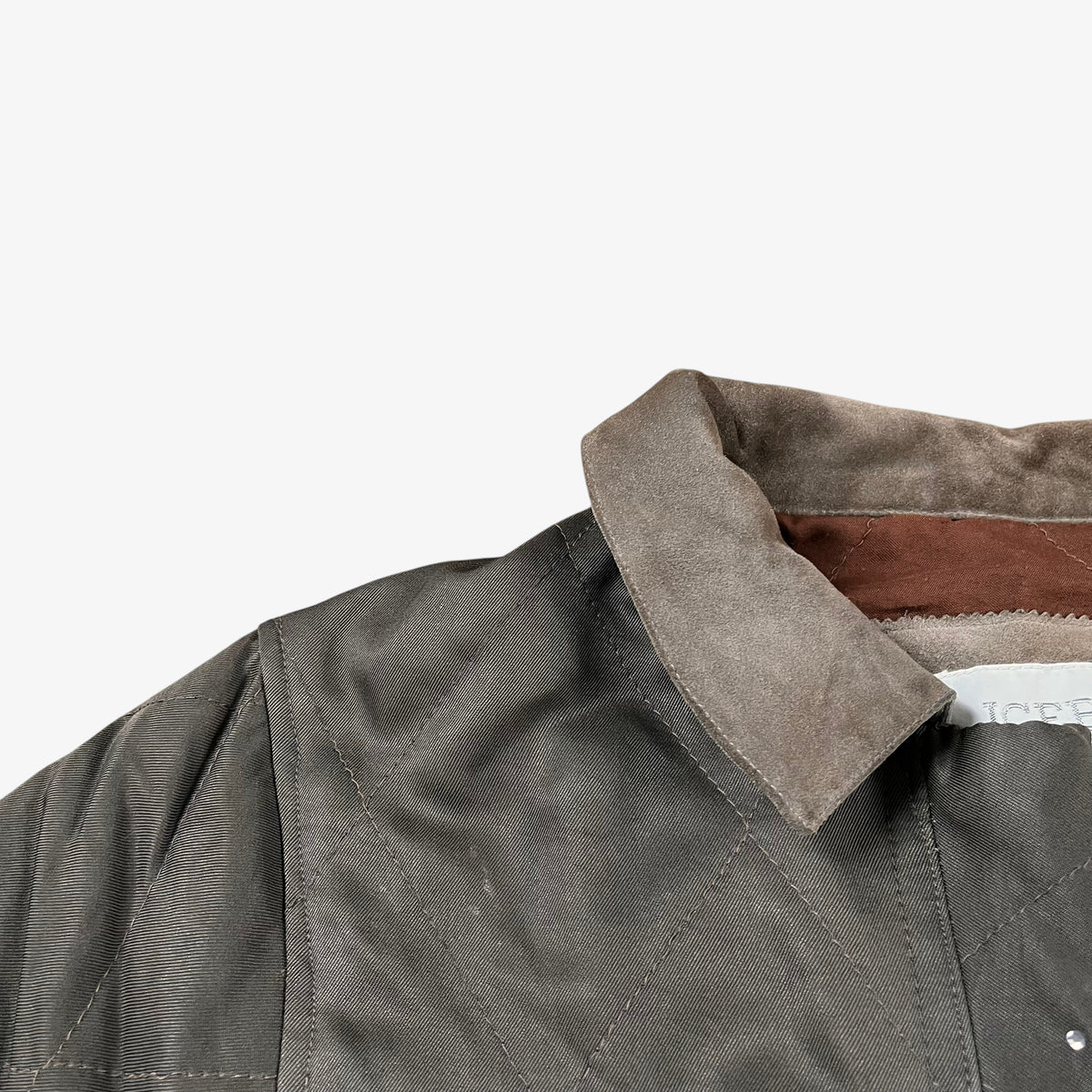 Leather collar of vintage 90s Iceberg women’s khaki quilted bomber jacket with Disney Aristocats embroidery.