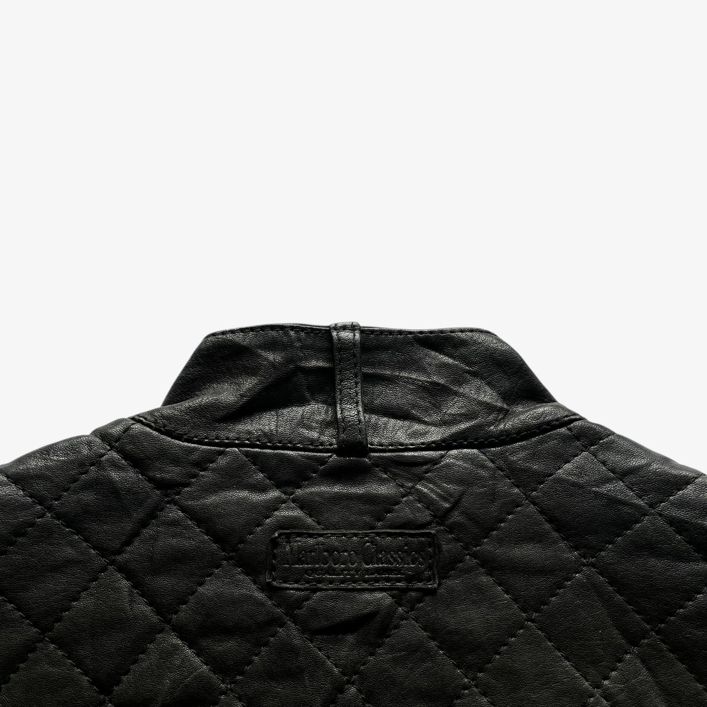 Back Marlboro Classics collar tag on a women's black quilted leather biker jacket.