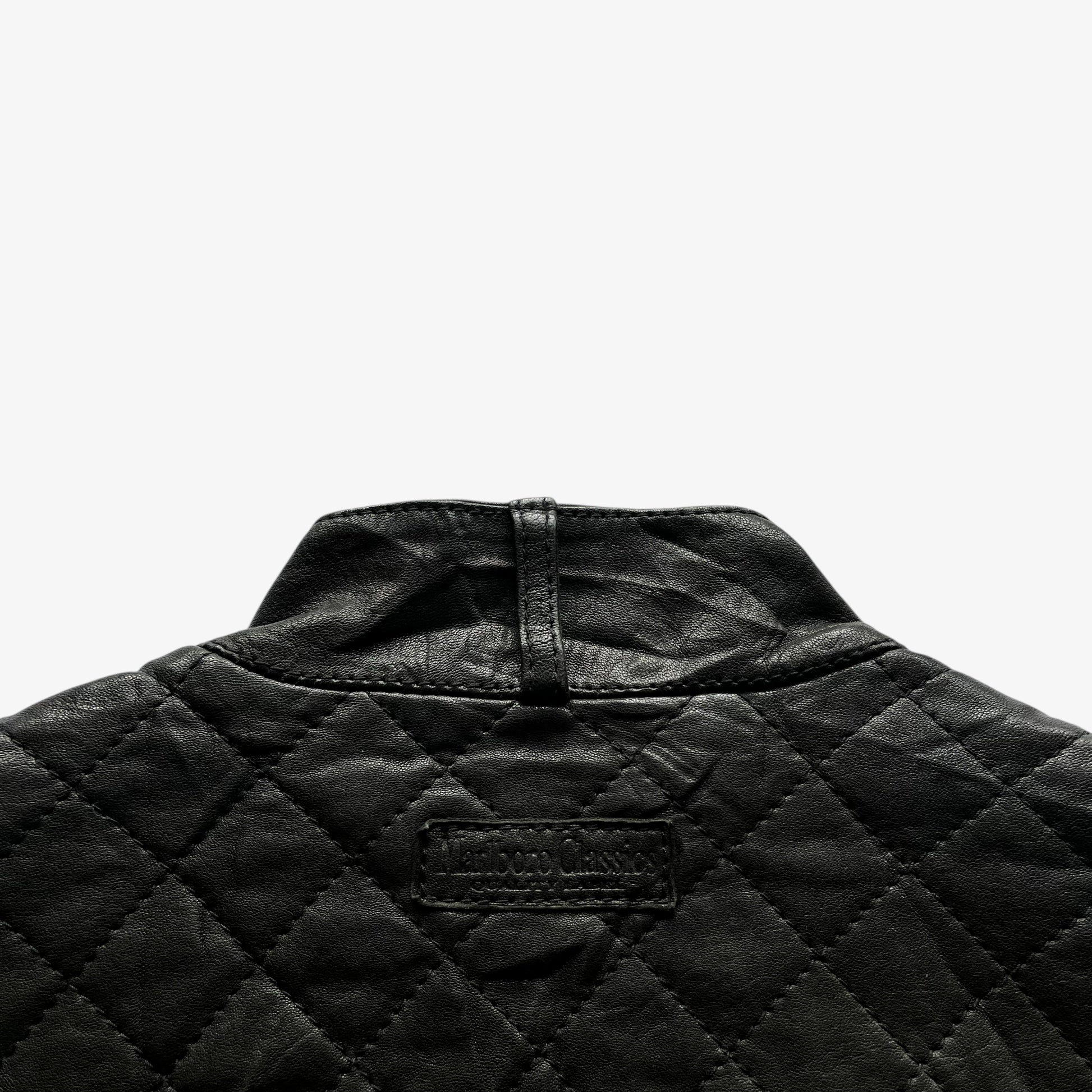 Back Marlboro Classics collar tag on a women's black quilted leather biker jacket.