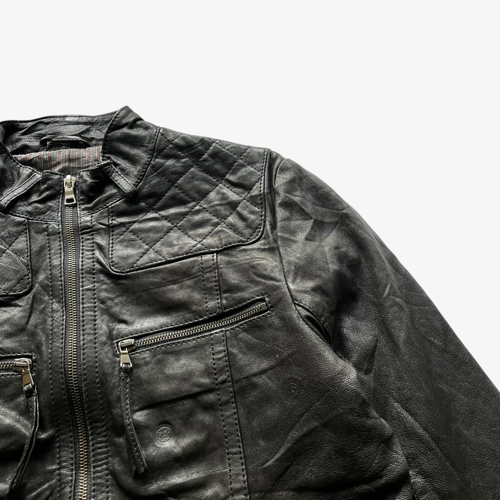 Zipped utility pockets on a vintage 90s women's Marlboro Classics black quilted leather biker jacket.