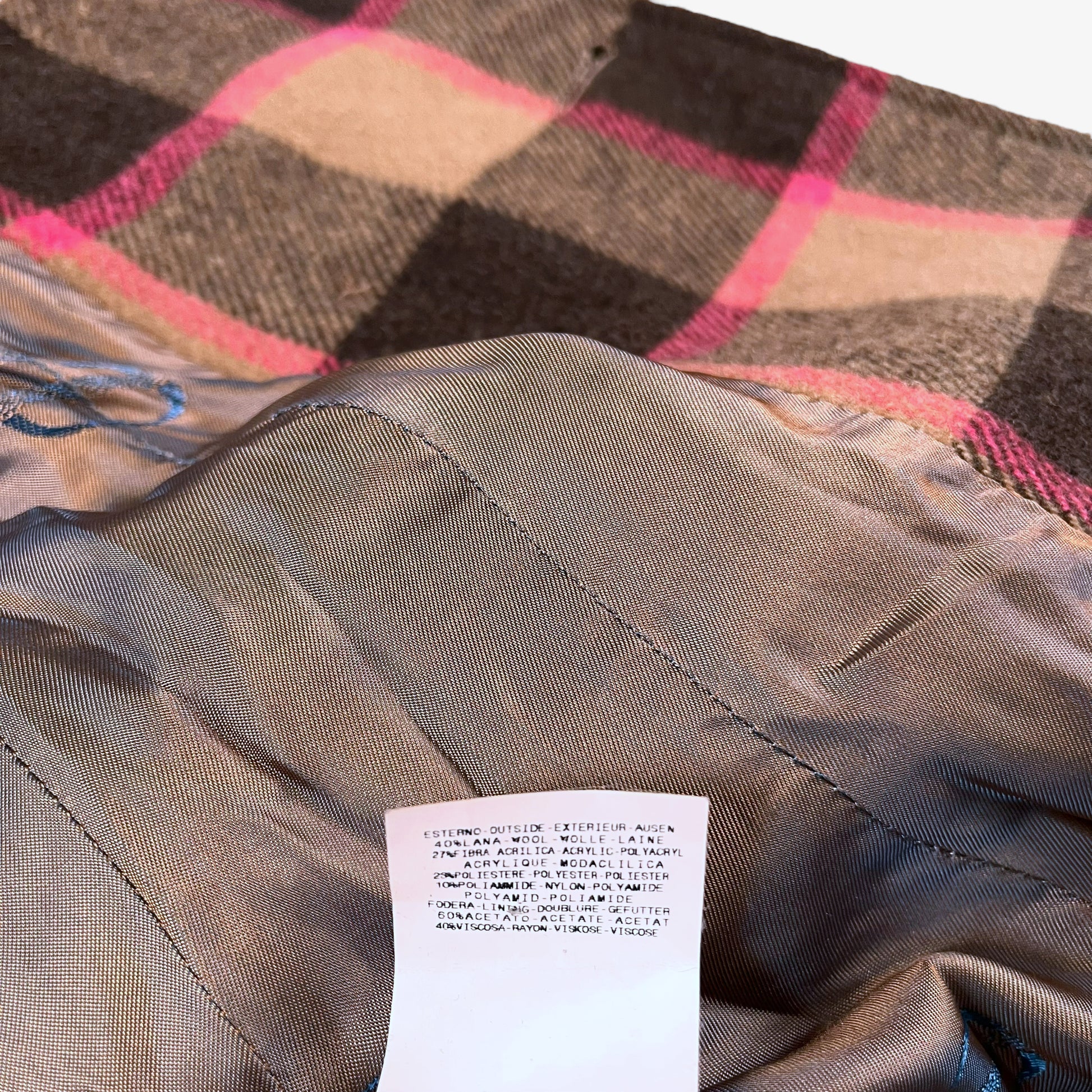 Material label inside of vintage 90s Roberto Cavalli women’s brown and pink tartan and plaid double breasted wool blend coat.