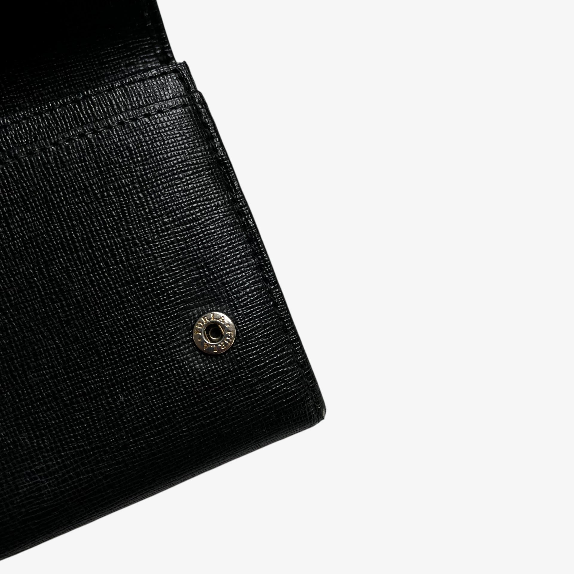 Furla engraved button on a vintage Y2K black leather continental flap wallet.