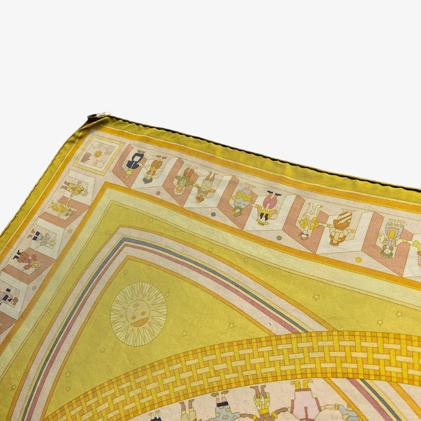 Hand rolled edges on vintage Y2K women's Hermes Paris Donner La Main geometric sun face print yellow silk scarf.