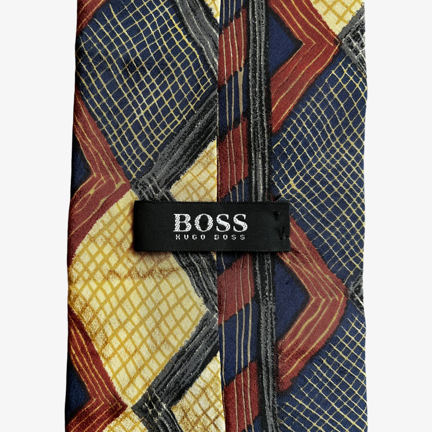 Label on vintage Y2K Hugo Boss contrasting colourful striped and checkered print silk tie.
