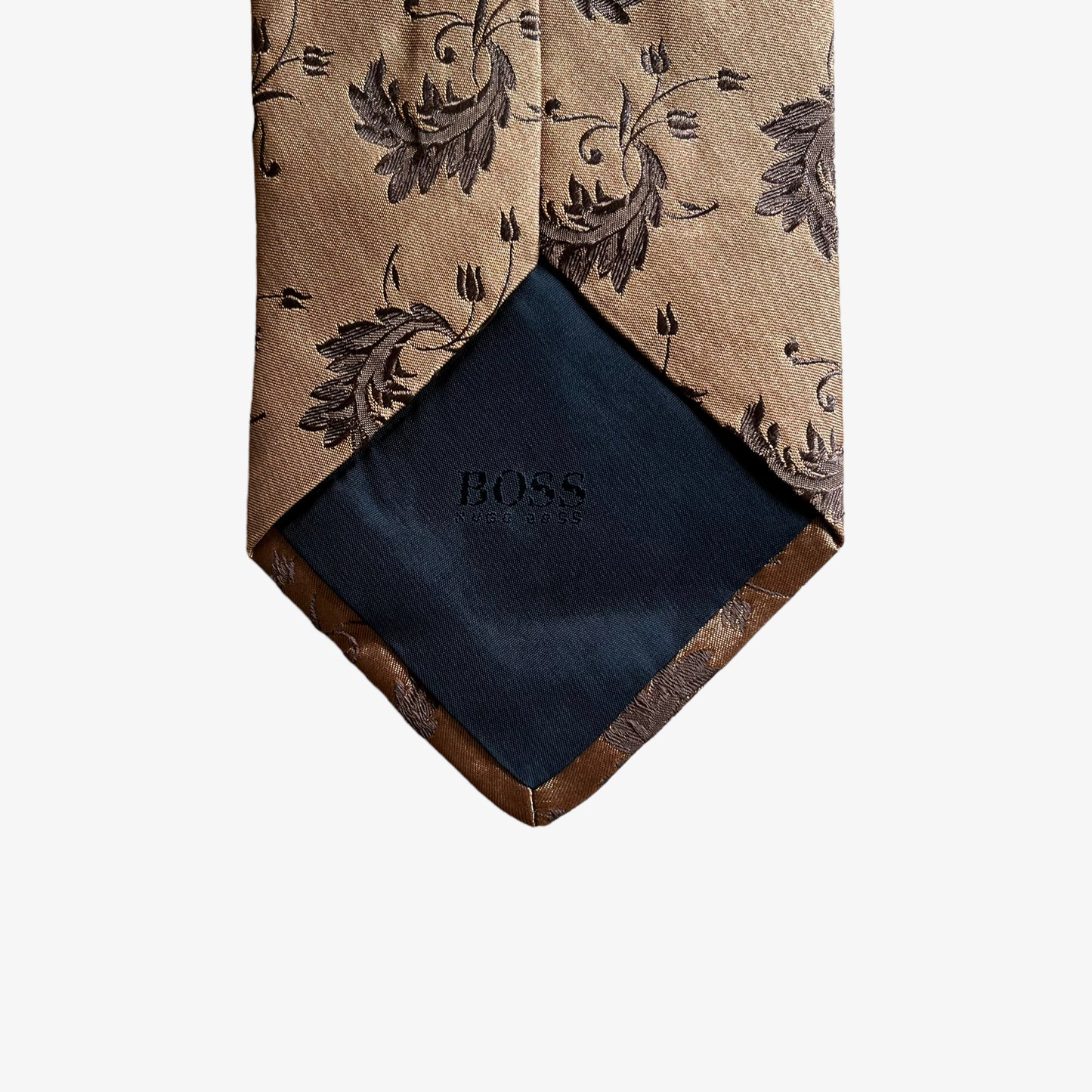 Back of vintage Y2K Hugo Boss brown silk tie features a geometric floral leaf pattern.