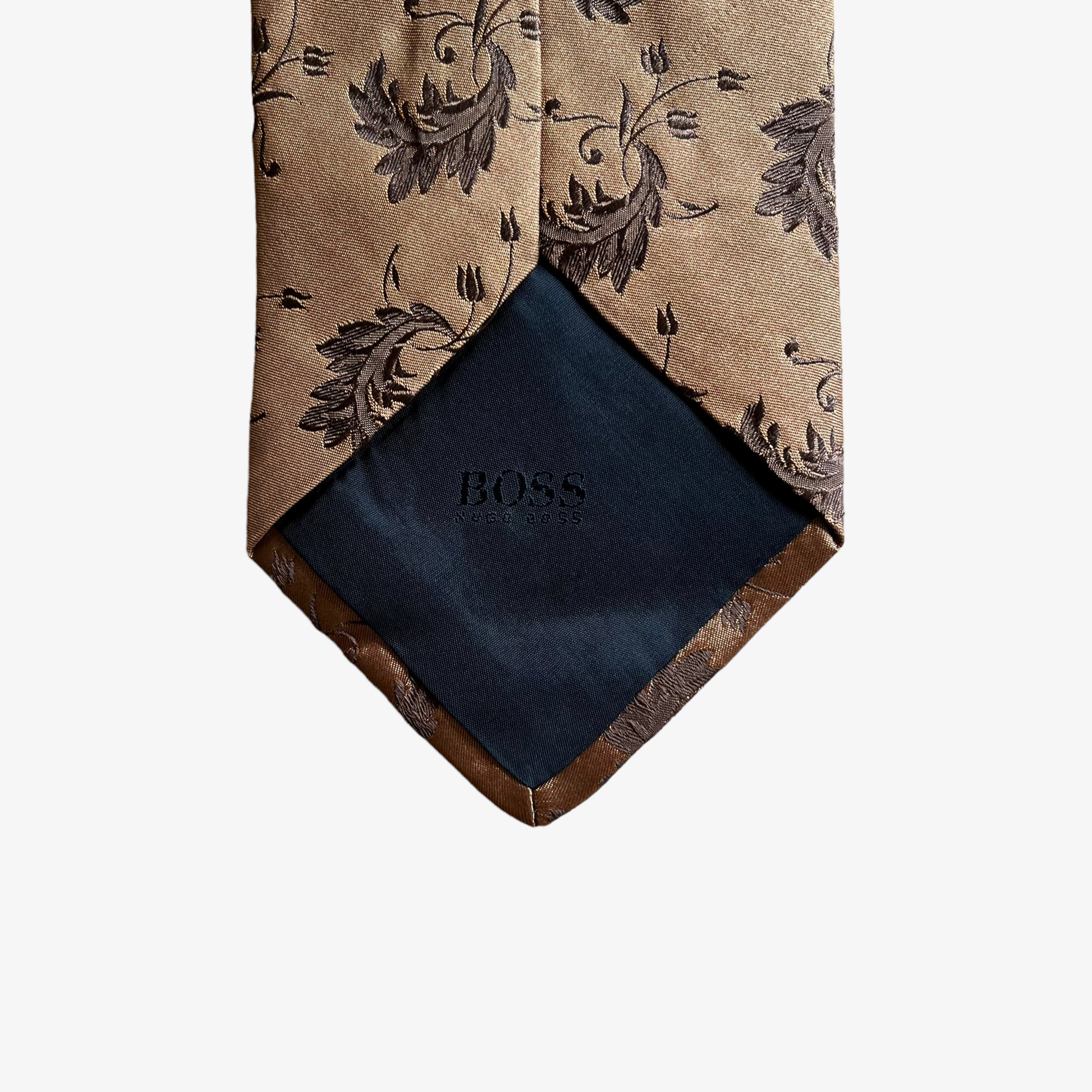 Back of vintage Y2K Hugo Boss brown silk tie features a geometric floral leaf pattern.