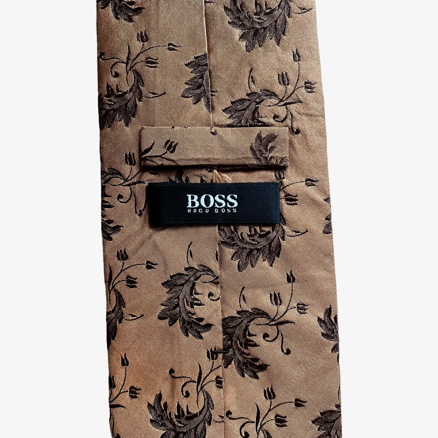 Label on vintage Y2K Hugo Boss brown silk tie features a geometric floral leaf pattern.