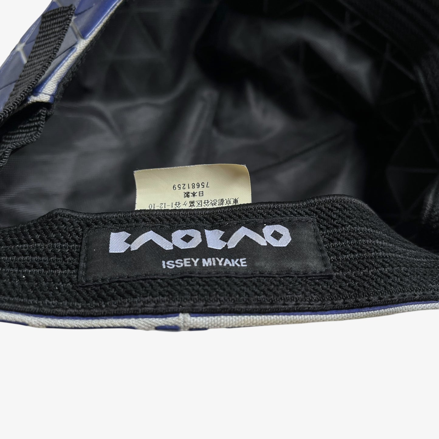 Issey Miyake bao bao label stitched inside of vintage Y2K blue geometric cap.