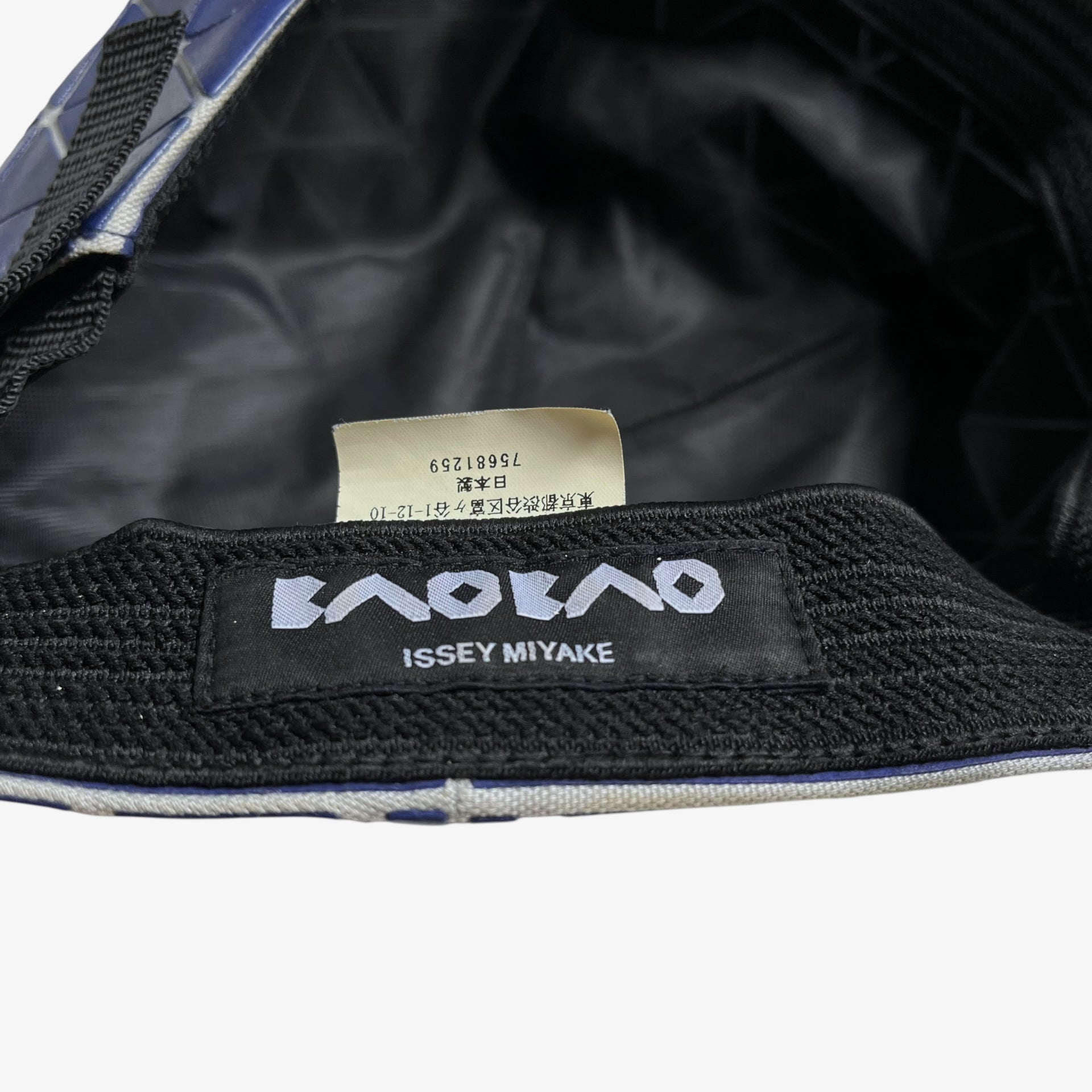 Issey Miyake bao bao label stitched inside of vintage Y2K blue geometric cap.