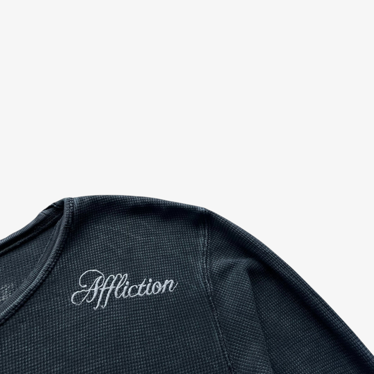 Embroidered Affliction spell out on the shoulder of a vintage Y2K men's textured long sleeve faded navy thrashed t-shirt.