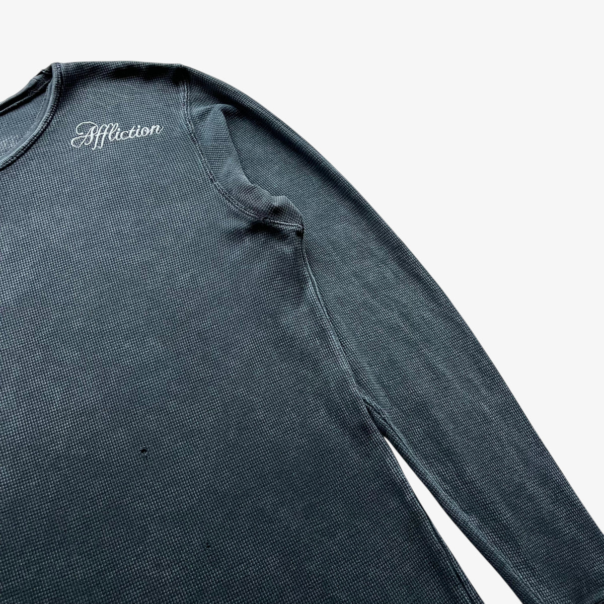 Wear on the chest of a vintage Y2K men's textured Affliction long sleeve faded navy thrashed t-shirt.
