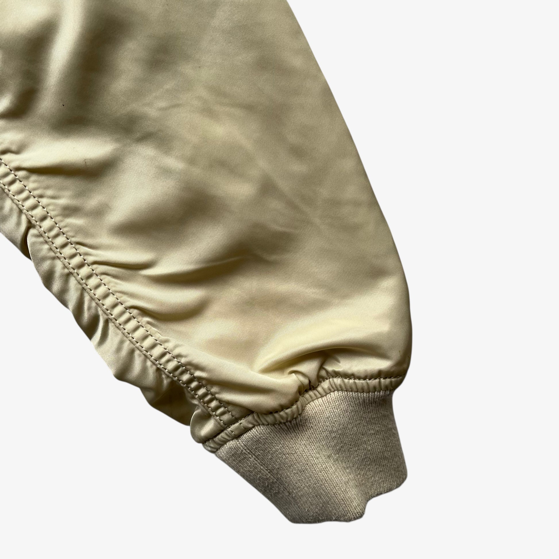 Cuff of vintage Y2K men's Alpha Industries beige bomber jacket.