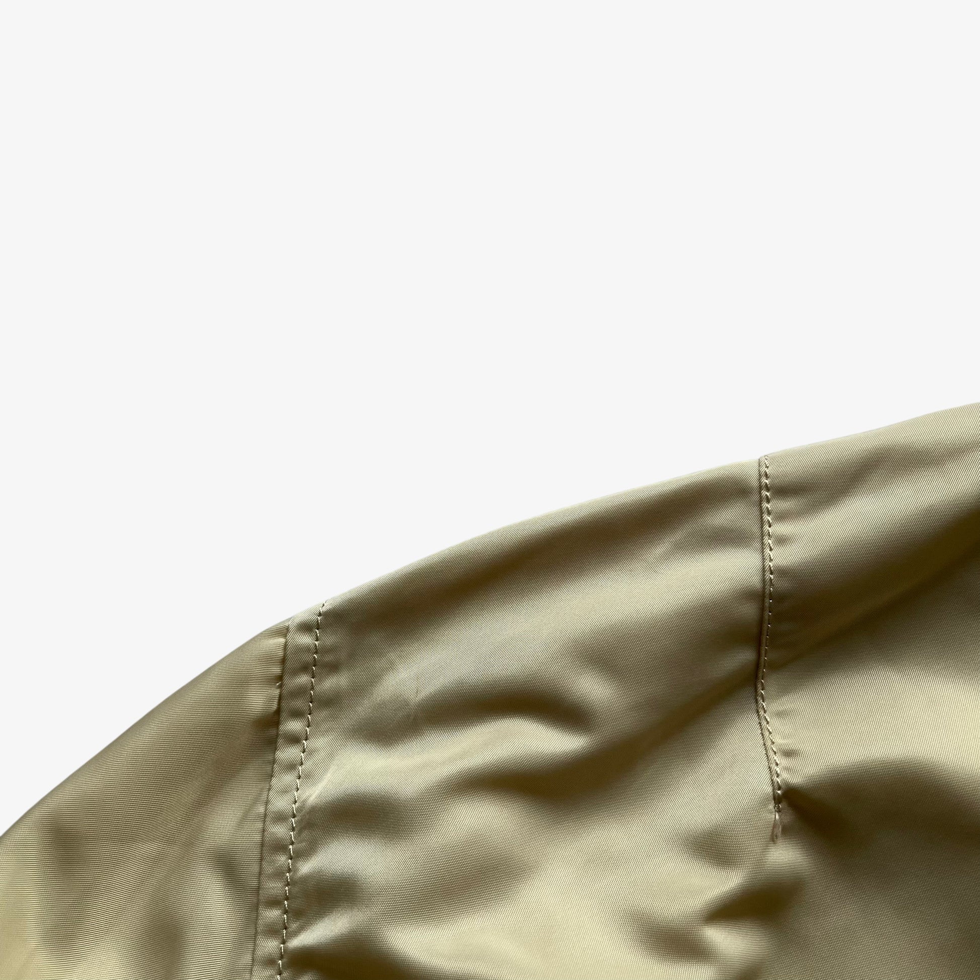 Patina on vintage Y2K men's Alpha Industries beige bomber jacket.